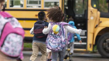 students running towards yellow school bus