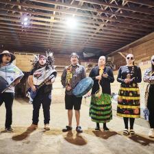 Indigenous Drummers and singers standing in the longhouse