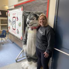 Teacher posing with school mascot